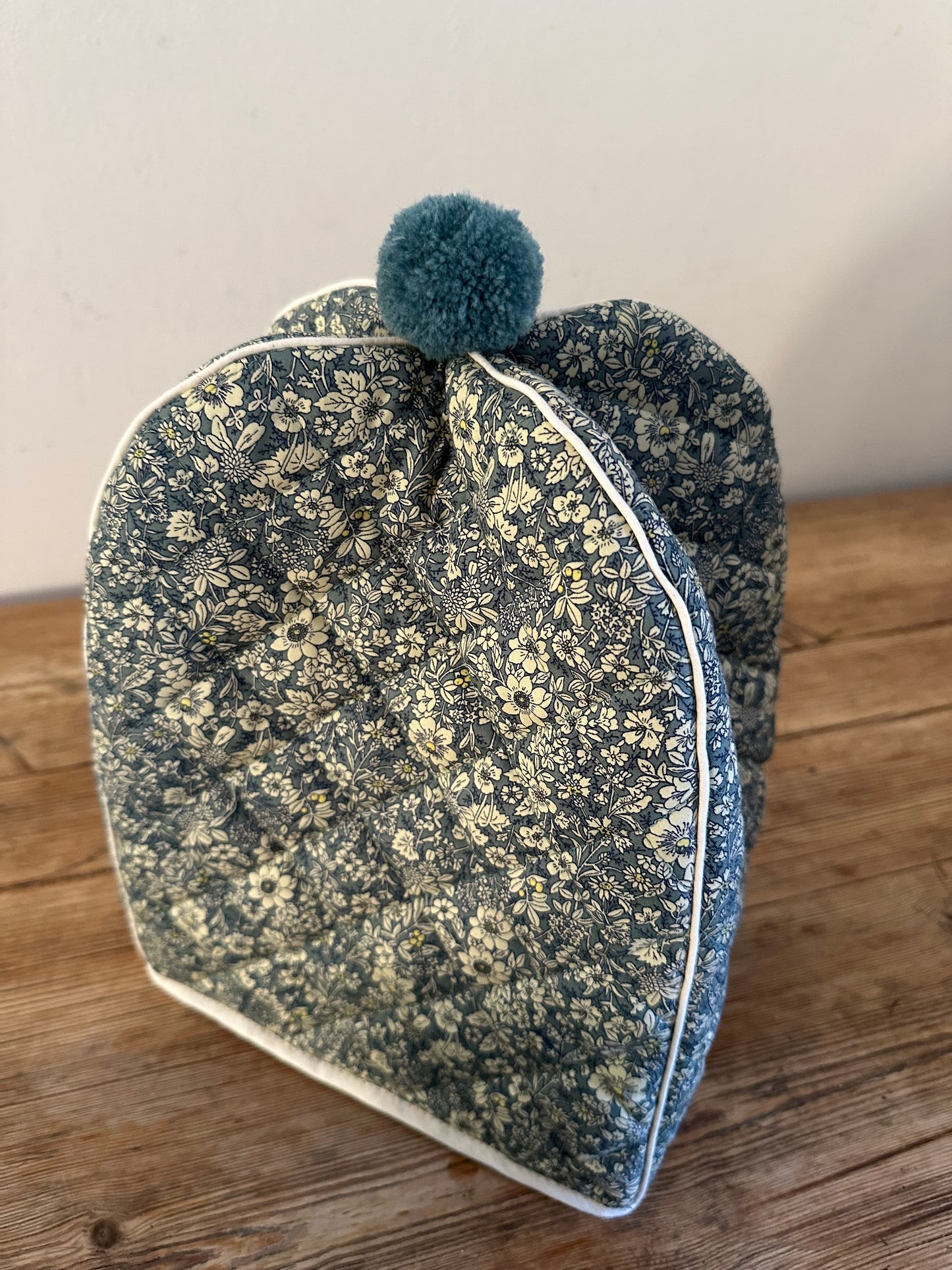 Håndsyet tehætte med pompon - blomstret bomuld