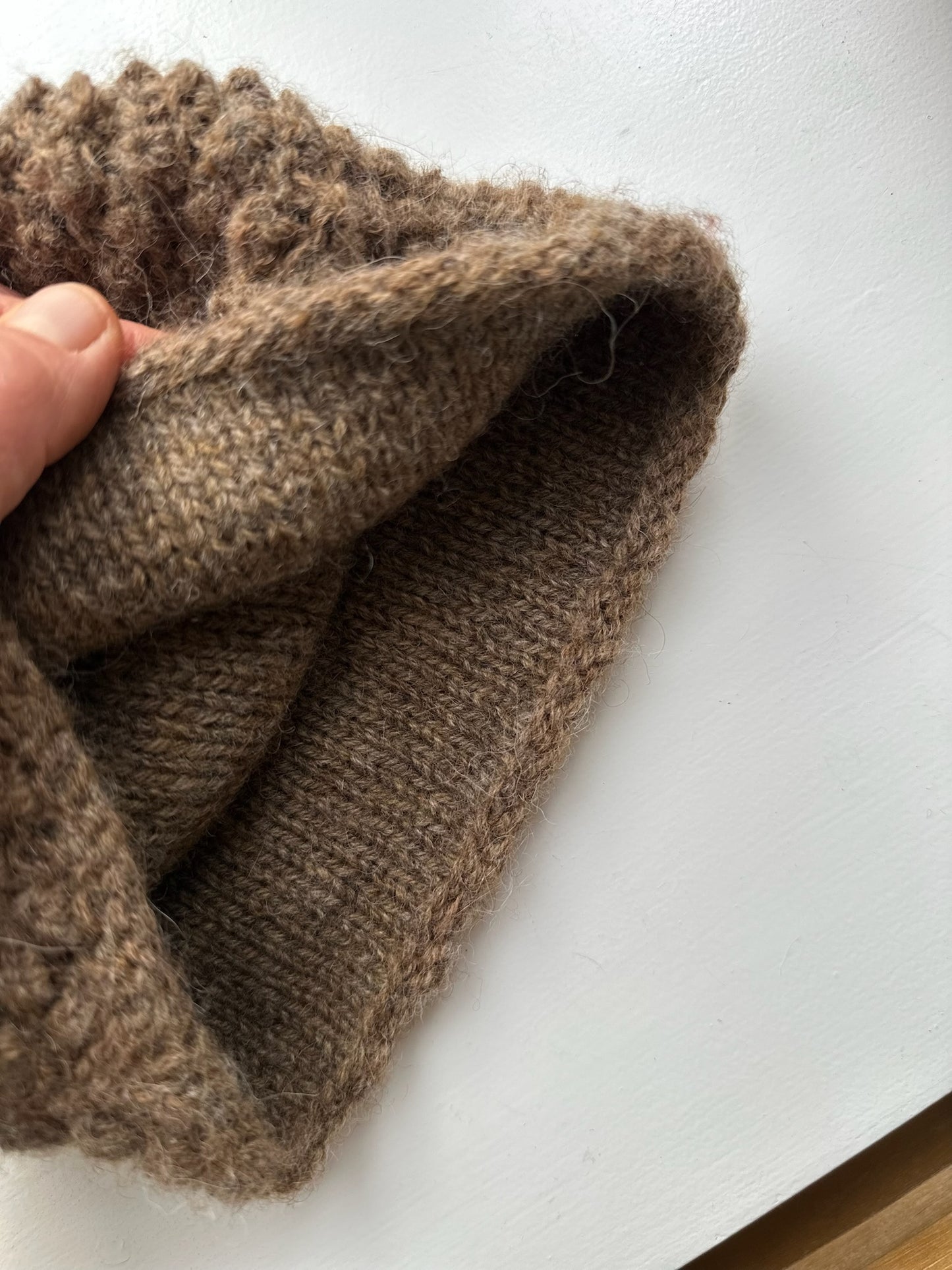 Håndstrikket tehætte med pompon - brun uld