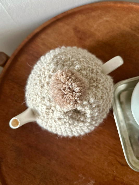 Håndstrikket tehætte med pompon - beige uld