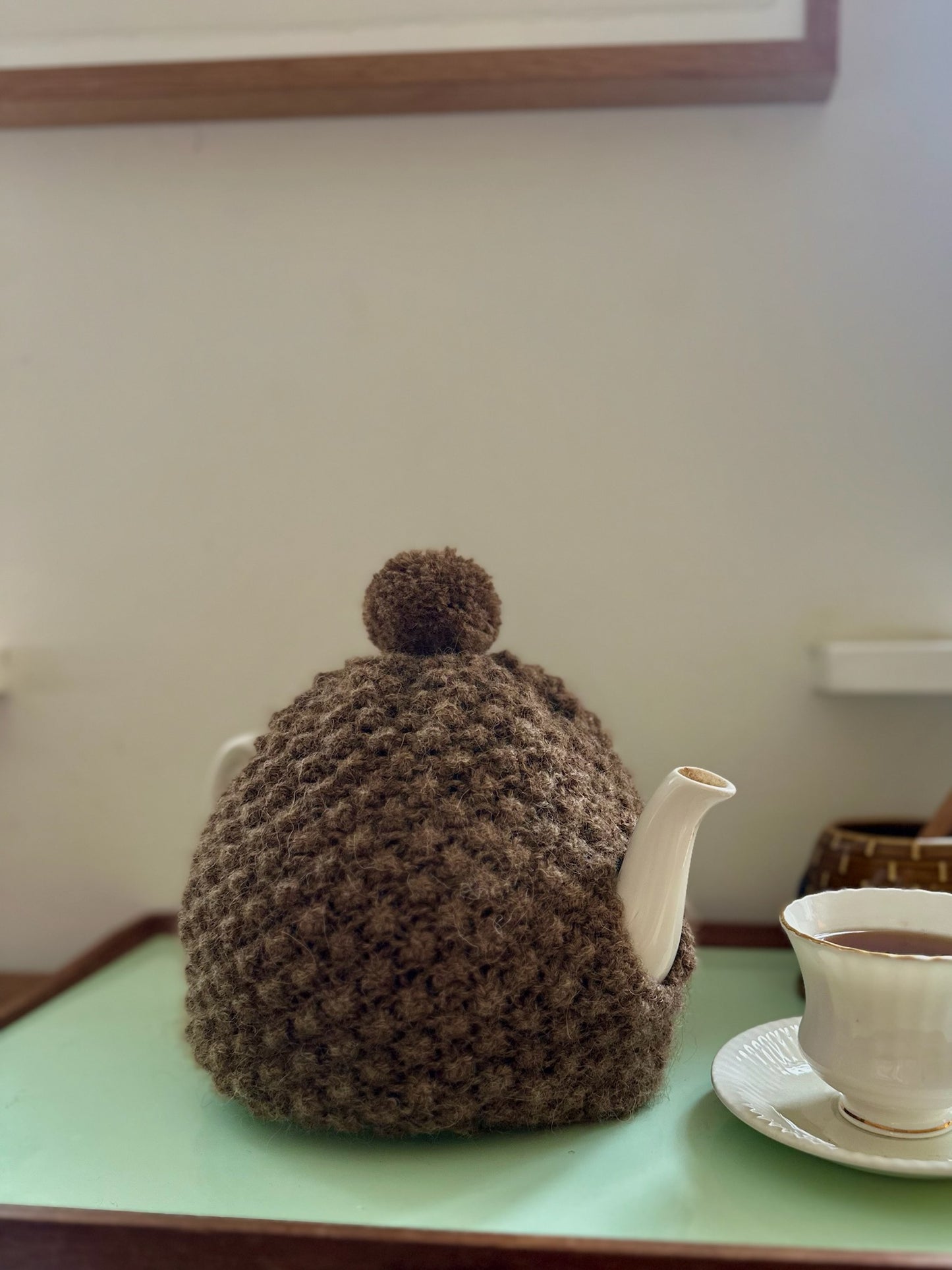 Håndstrikket tehætte med pompon - brun uld