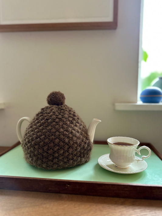 Håndstrikket tehætte med pompon - brun uld